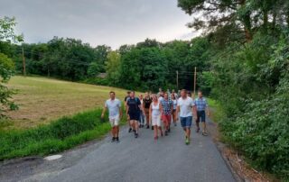 Wandergrzppe auf einer asphaltierten Straße im Grünen